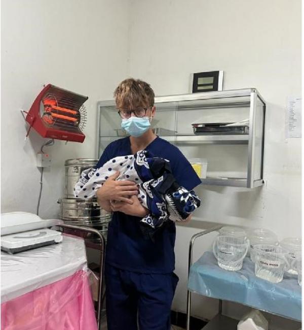 Henry holding a premature baby in the hospital