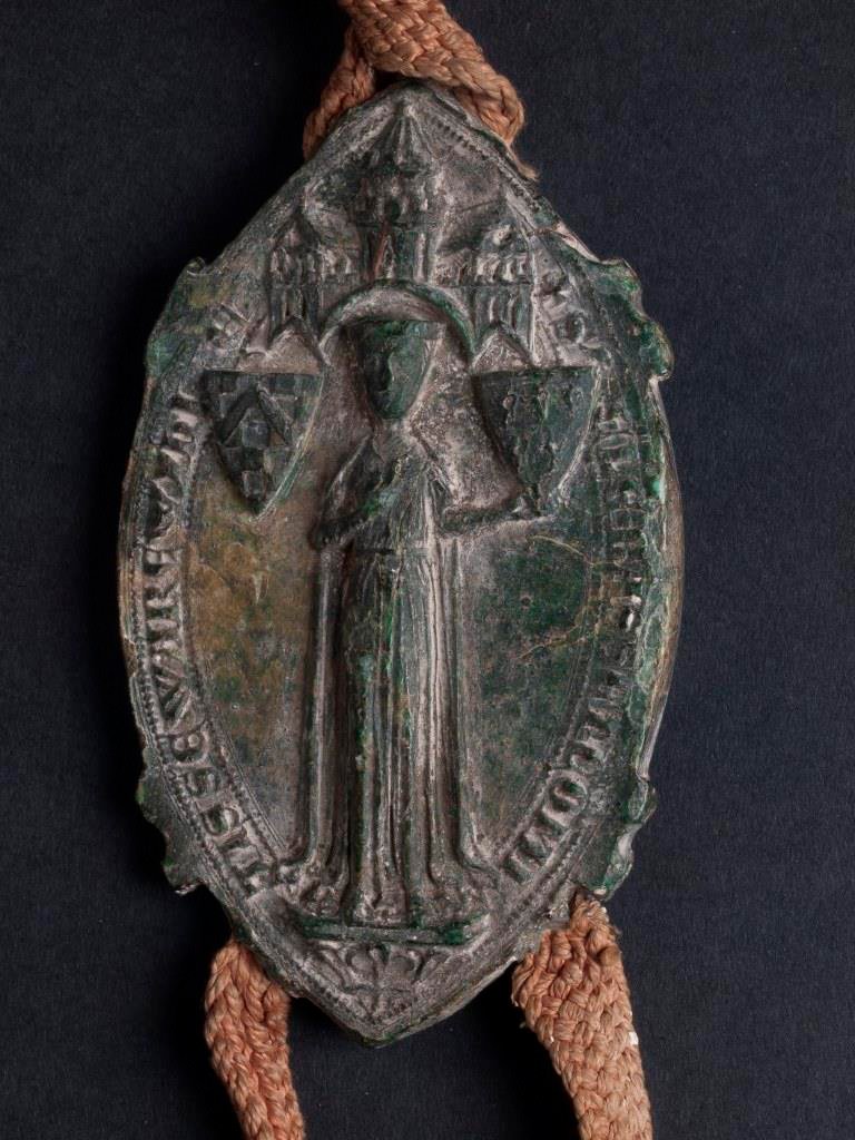 The seal of Ela of Warwick attached to the grant of the manor of Thorncroft, Surrey, which she made with her husband, Philip Basset, to Walter de Merton in November 1266. It is indicative of a person of considerable power and wealth. MCR 646.