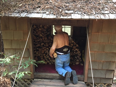 Tony stacking firewood in the woodshed