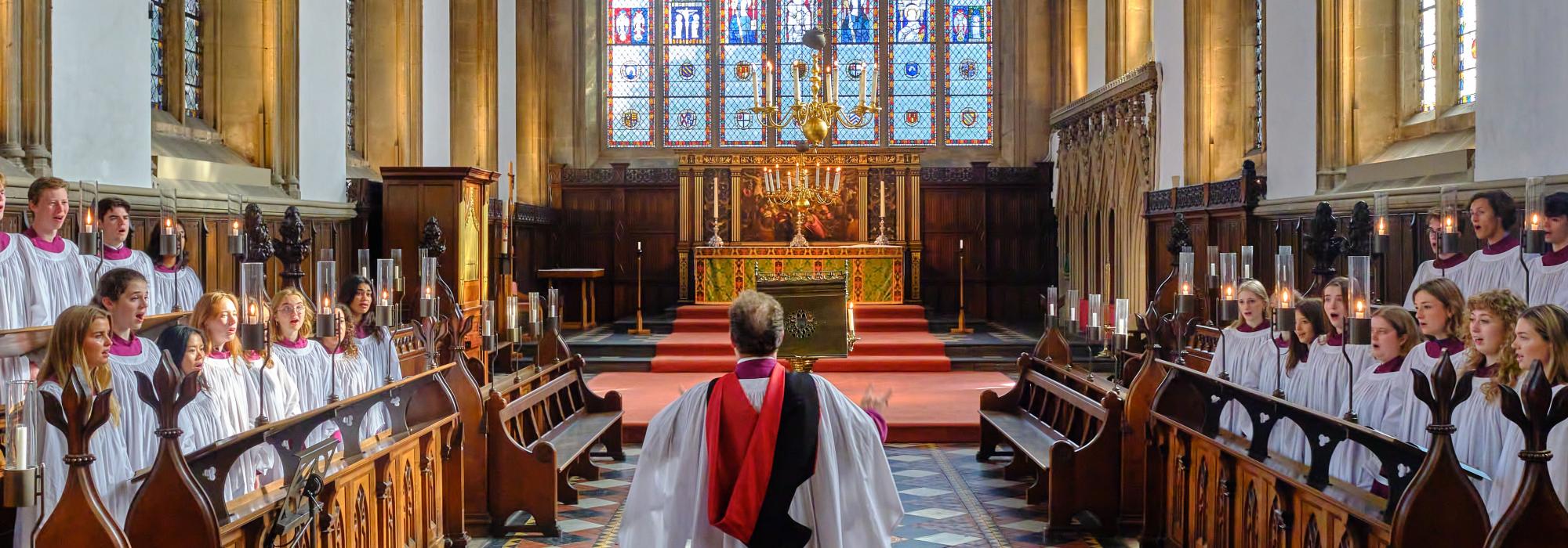 The choir in brightly lit chapel in purple and white robes