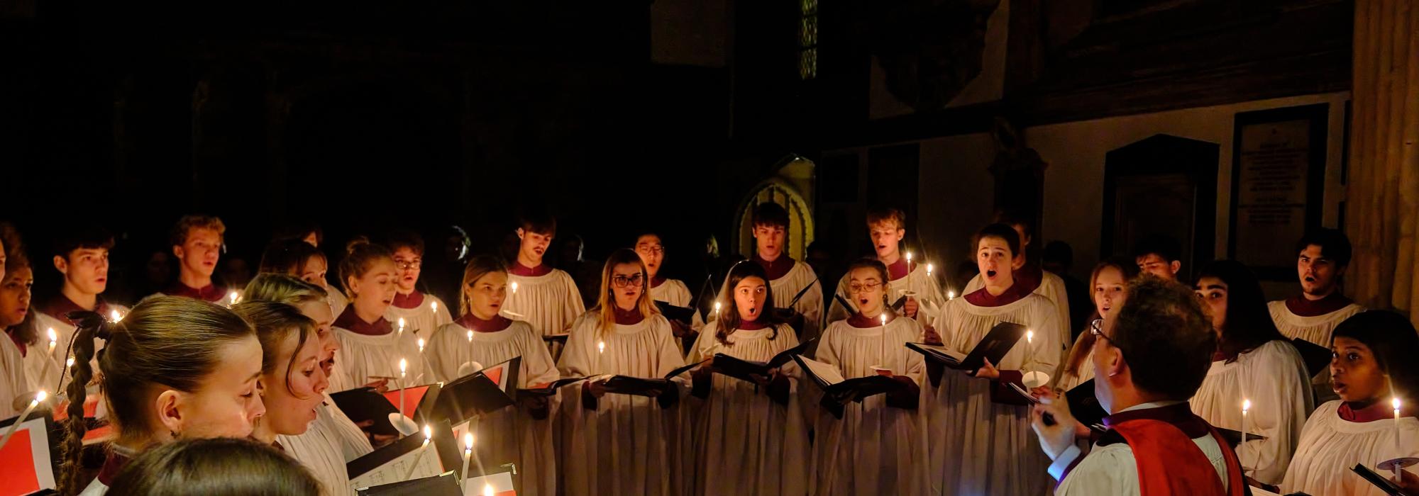 The choir in dimly lit chapel surrounded by candles