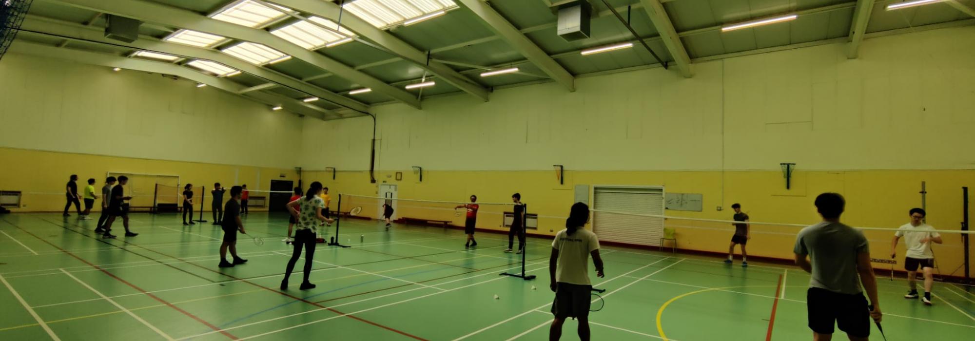 Badminton players practising on the courts