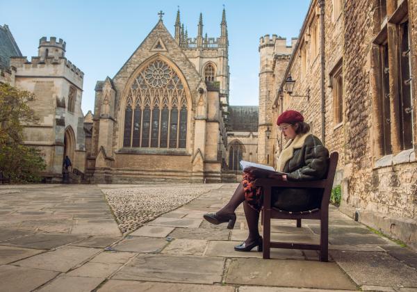 A student sitting on the bench in Front Quad.