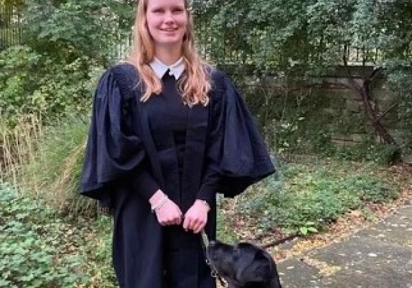 Student Ella Caulfield standing with Guide Dog Rio