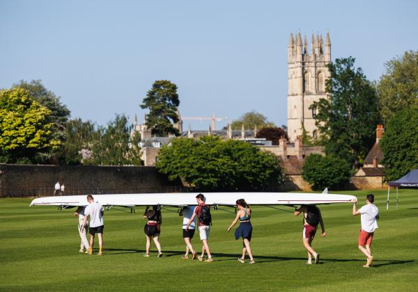 Group of students carrying a rowing boat