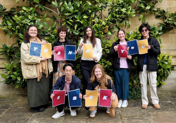 a group of young people holding cards spelling the words, 'thank you'