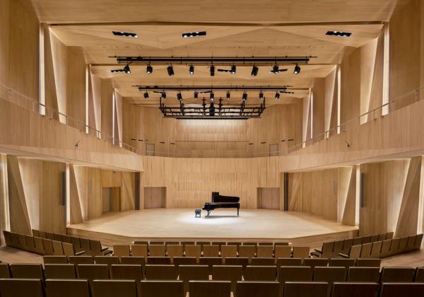 Munetsugu Hall Interior (a light wooden panelled stage with a black grand piano)