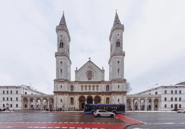 The exterior of a church with two grand towers and a central circular window