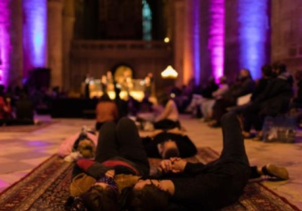 Cheltenham Mixtape An audience in a dimly lit building lying on carpets and beanbags