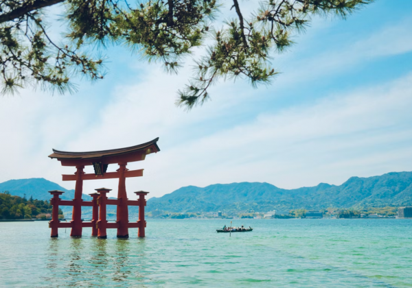 An orange torii gate in a green blue sea