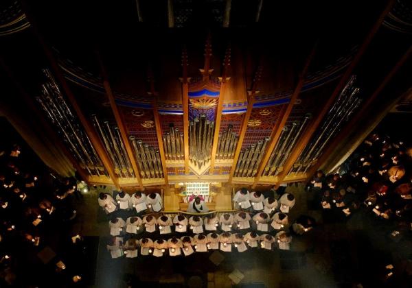 A view from above over the choir singing by the lit Dobson Organ