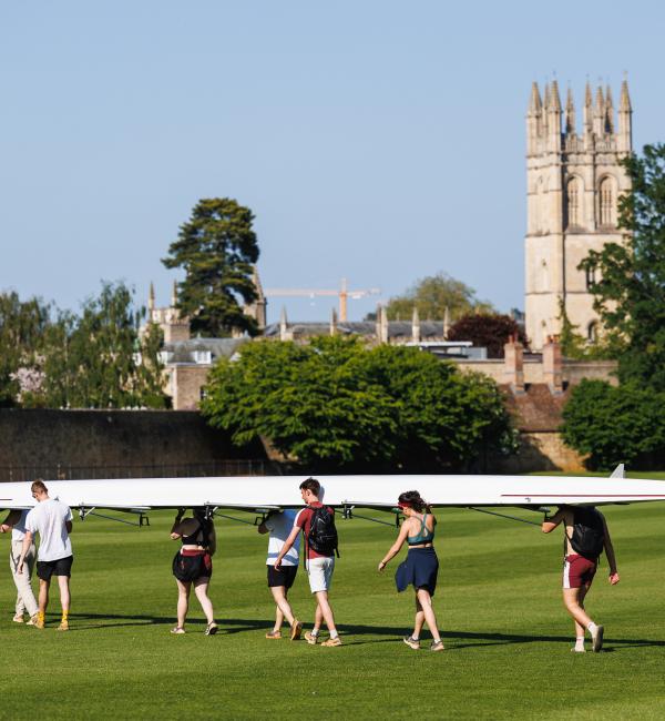 Group of students carrying a rowing boat