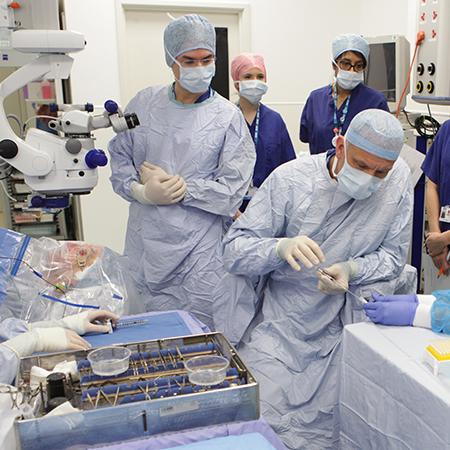 Professor Peter Charbel Issa (standing) checks the virus being drawn up by Professor Robert MacLaren - Photo: © Jon Brett, Eye Research Group Oxford