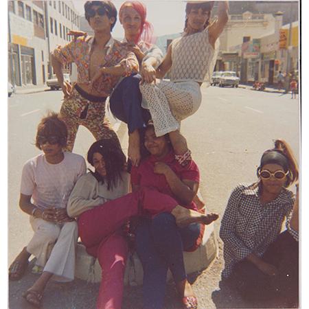 Kewpie (back row, centre) and friends on Sir Lowry Road, District Six, Cape Town - Photo © GALA Queer Archive, Kewpie Photographic Collection Kewpie (back row, centre) and friends on Sir Lowry Road, District Six, Cape Town - Photo © GALA Queer Archive, Kewpie Photographic Collection