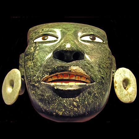 A mask made from a single piece of deeply coloured greenstone and inlaid with shell eyes and teeth, found at the Teotihuacan Great Temple, where it was buried in tribute to the majesty of the Mexica (Aztec) empire. Photo: Dennis Jarvis [CC BY-SA 2.0]