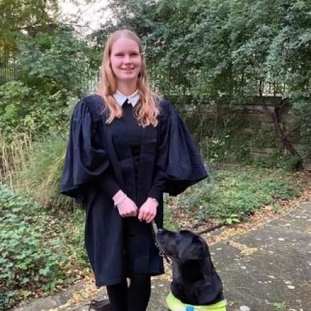 Student Ella Caulfield standing with Guide Dog Rio