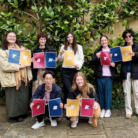 a group of young people holding cards spelling the words, 'thank you'