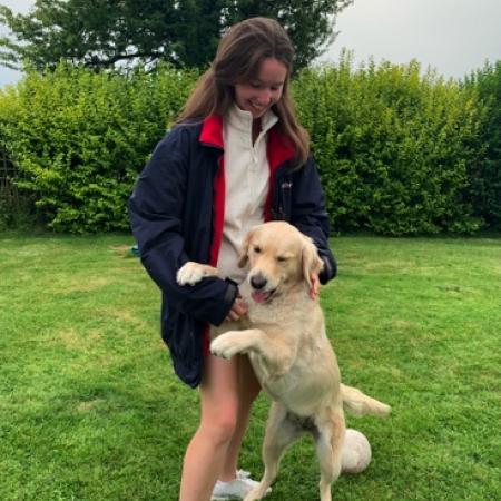 Cara Treacy young woman on a lawn with a dog