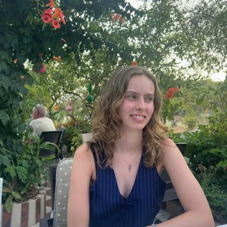 young woman seated at a table with flowers